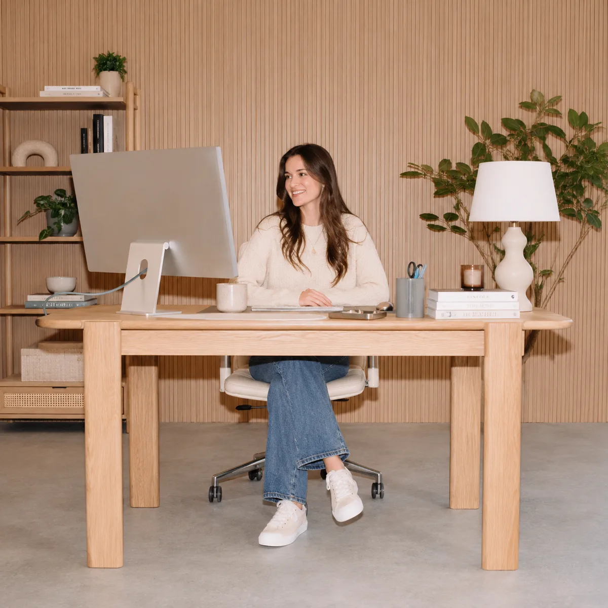 Creator at a home office desk with monitor, reviewing business records on screen
